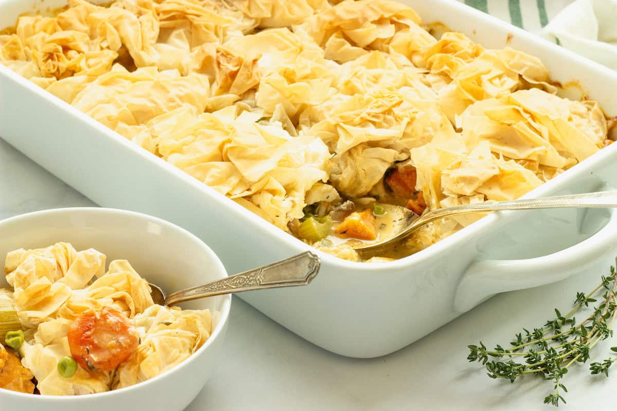 A white rectangular casserole dish and a small white bowl with chicken pot pie casserole.