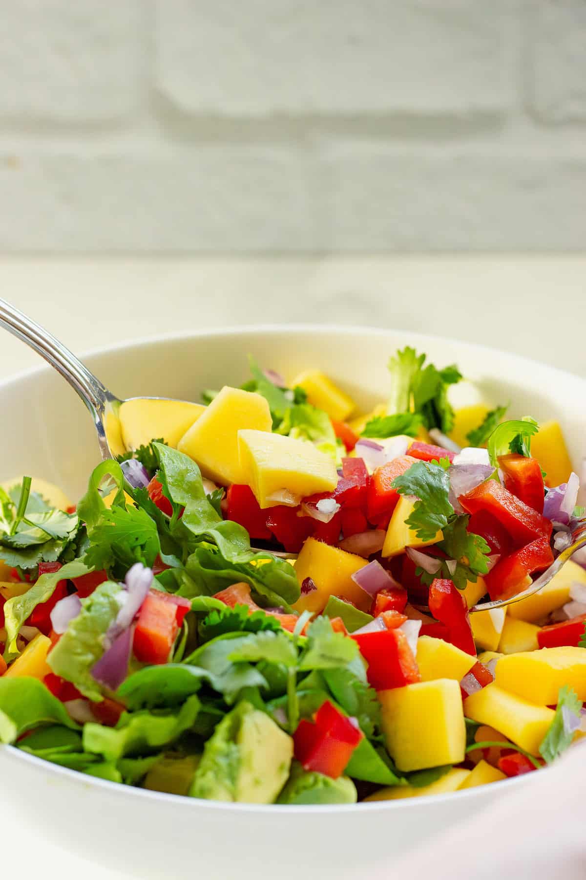 Step 2 to make a mango avocado salad, lightly toss you you don't mash the avocado