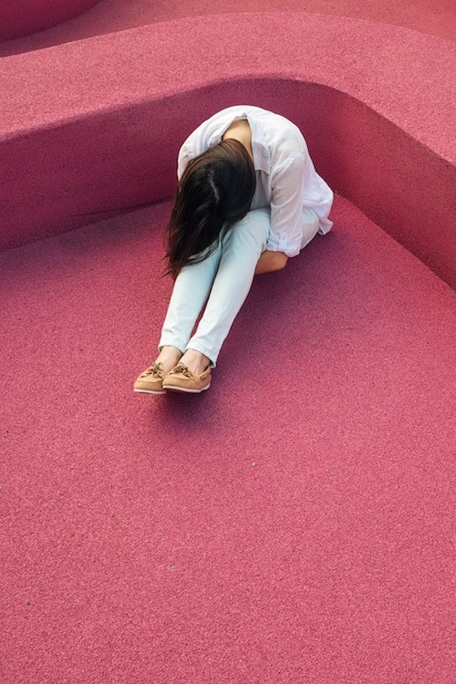 woman in a pink room looking stressed