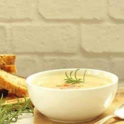 Creamy white bean fennel soup in a white bowl garnished with fresh rosemary
