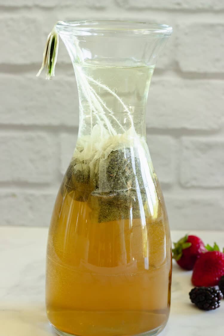 A carafe of green  sun tea brewed for four hours.  