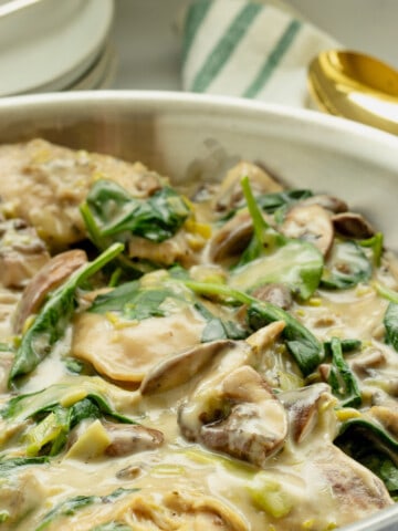 A pan of creamy chicken with spinach and mushrooms