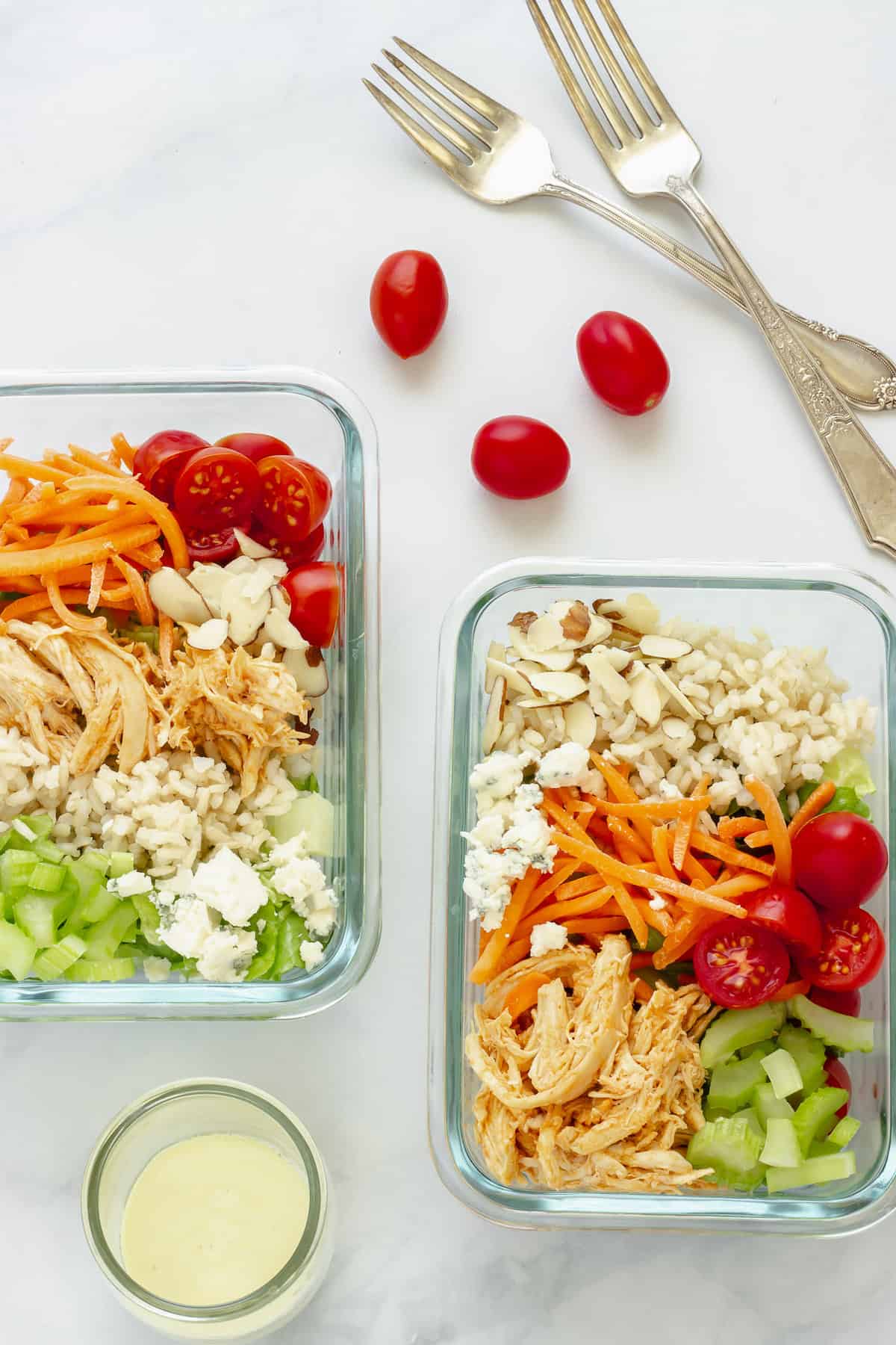 Two meal prepped containers of Buffalo chicken rice bowls.