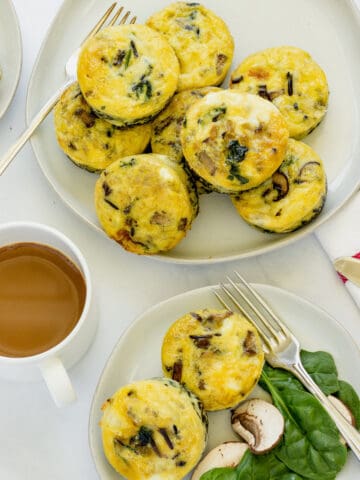 A platter of egg muffin cups next to a cup of coffee and a smaller plate of 2 egg muffins