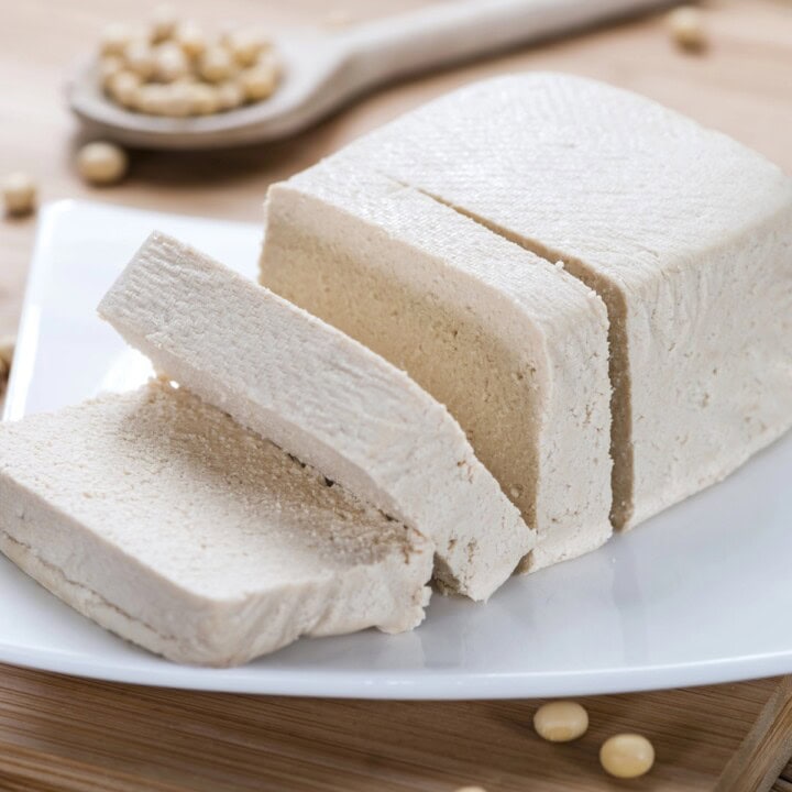 A block of fresh tofu, sliced.