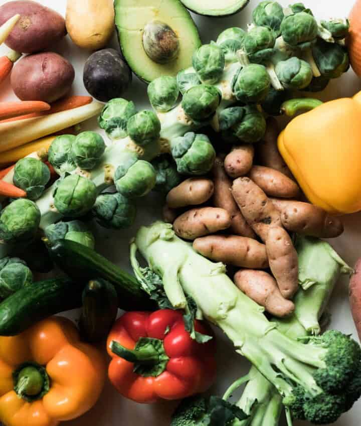 various raw vegetables on a wood board.