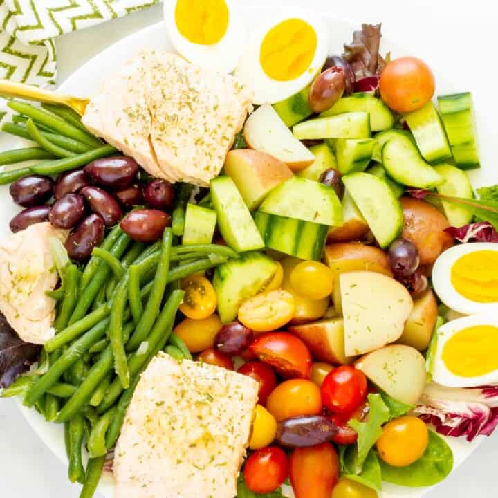 A composed platter of salmon Nicoise salad.